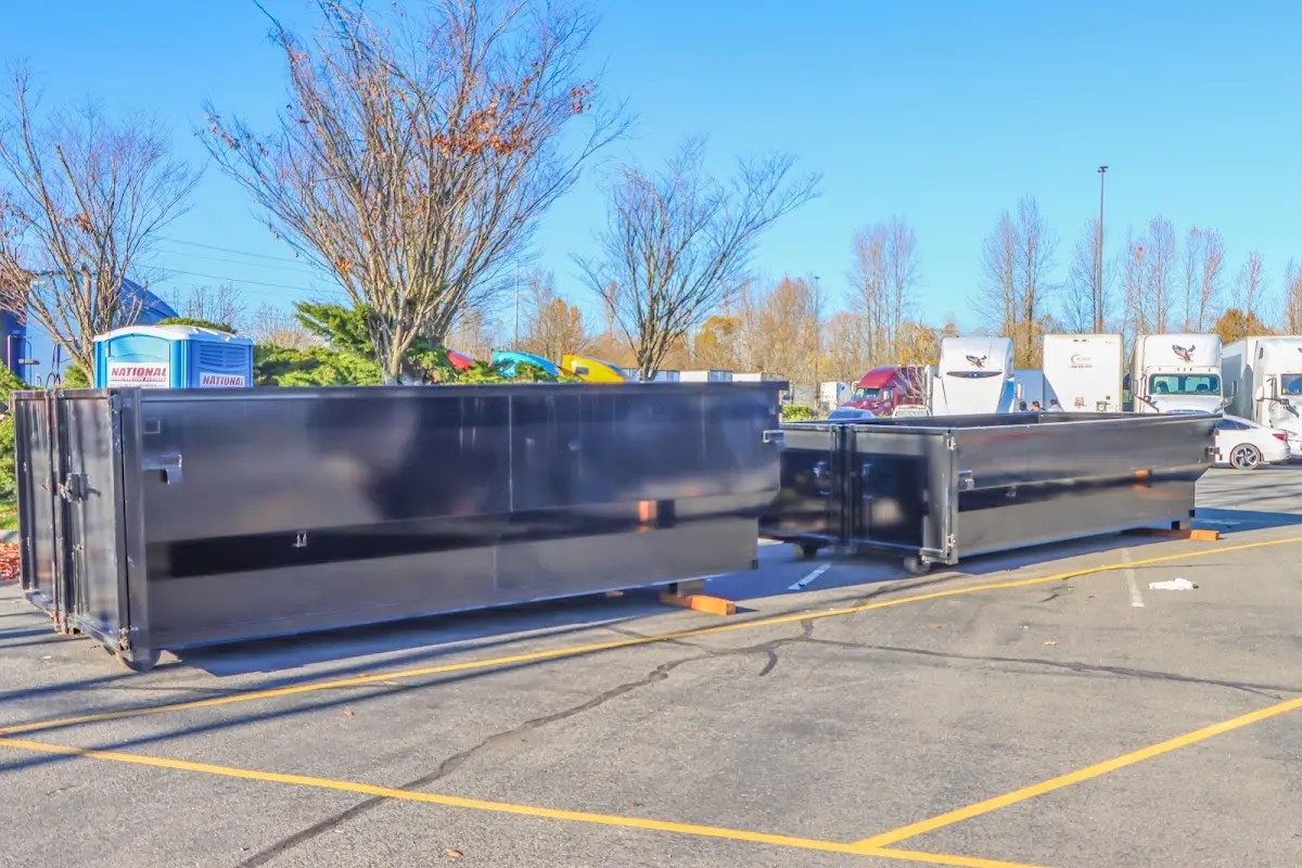 Professional dumpster rental service with roll-off container on residential driveway in Rockaway